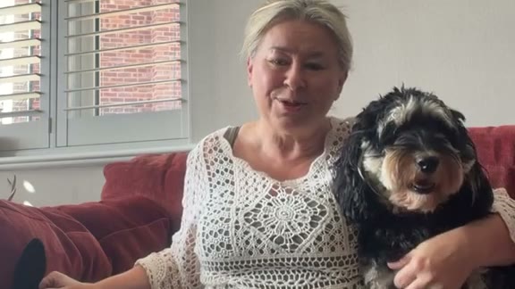 Sharon recording a thank you at home with her dog